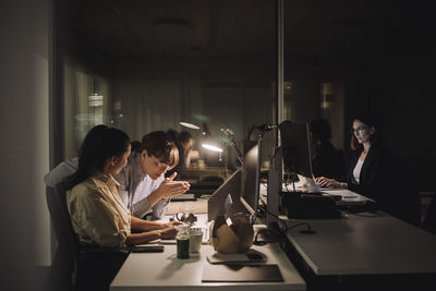 Young female colleague discussing with businesswoman at work place