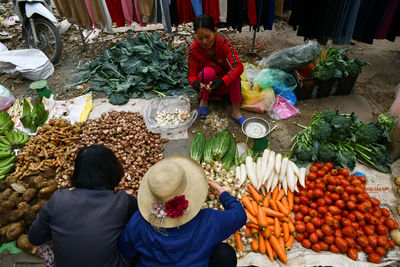 Rear view of people for sale at market stall