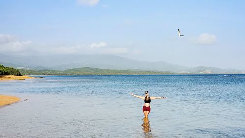 Rear view of man with horse in sea