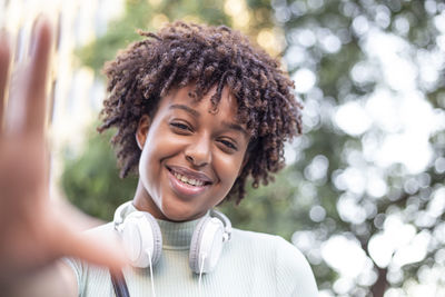  young mixed race female model expressing energy .charming afro woman with headphones takes a selfie