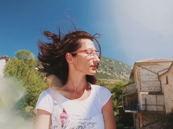 Young woman with sunglasses against sky