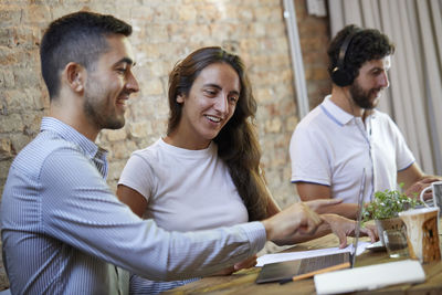 Side view of friends sitting on table