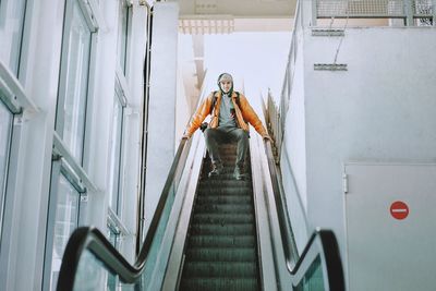 Low angle view of man humping over escalator