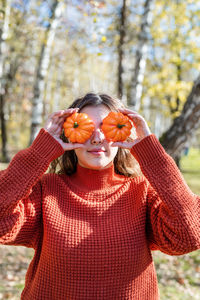 Leisure, free time. beautiful caucasian woman in red sweater on a picnic outdoors, sitting on a pl