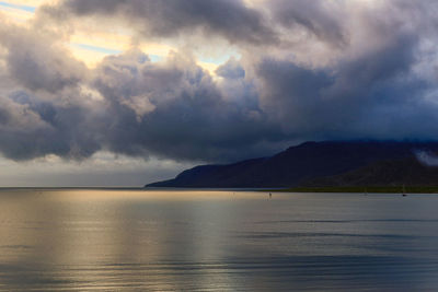 Scenic view of sea against storm clouds