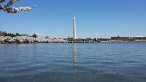 Washington monument by potomac river against sky