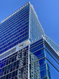 Low angle view of modern building against clear blue sky