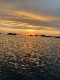 Scenic view of sea against dramatic sky during sunset