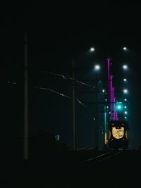 Illuminated train against sky at night