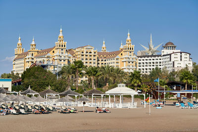 People at beach against clear sky