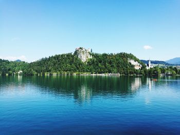 Scenic view of lake against clear blue sky