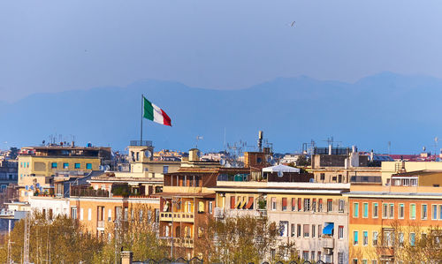 Flag against buildings in city against clear sky