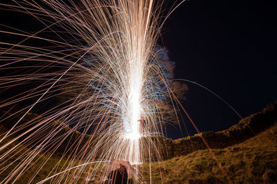 Low angle view of firework display at night