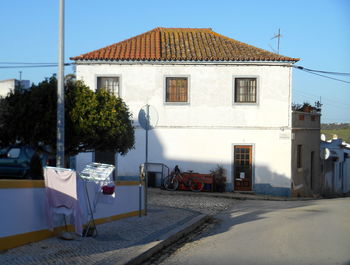 Road by building against clear sky