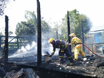 Men working on fire hydrant against trees