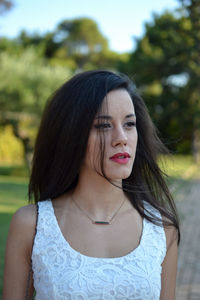 Portrait of beautiful woman standing against blurred background