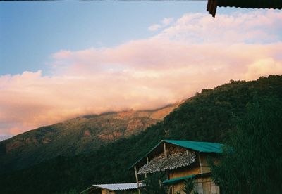 Scenic view of house and mountains against sky