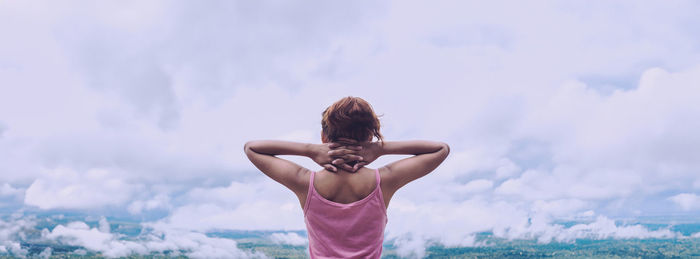 Low angle view of woman standing against sky