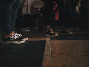 Low section of people standing on tiled floor