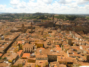 Aerial view of cityscape against cloudy sky