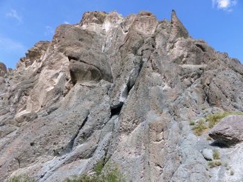 Low angle view of rock formation on land against sky