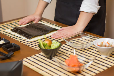 Midsection of woman preparing food on table