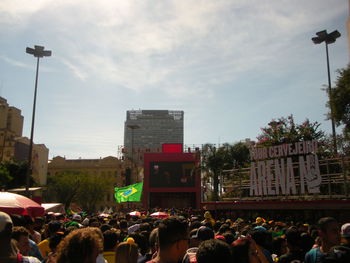 People on street in city against sky