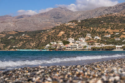 Scenic view of sea by city buildings
