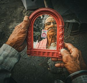 High angle view of man holding cross on hand