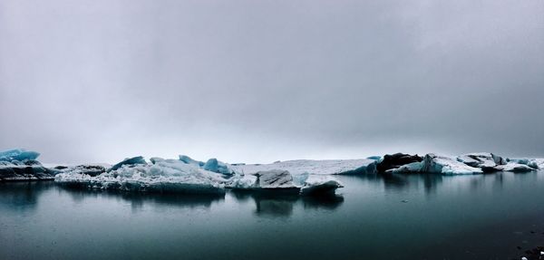 Scenic view of lake against sky during winter