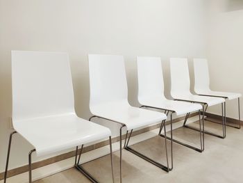 Empty chairs and table against wall at home