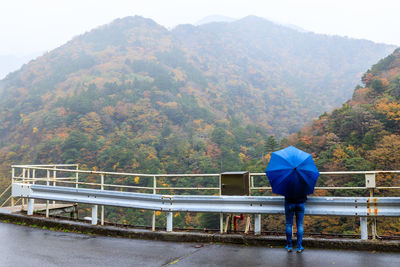 Rear view of man with umbrella on rainy day