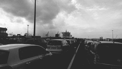 Cars on road against cloudy sky