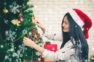 Midsection of woman with christmas tree