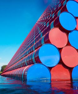 Pipes floating on water against blue sky