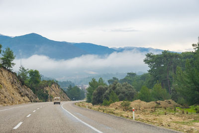 People walking on road against sky