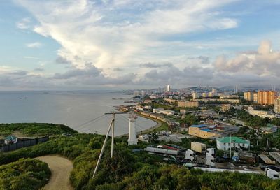 High angle view of cityscape by sea against sky