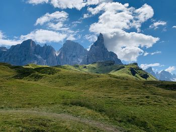 Scenic view of green landscape and mountains against sky