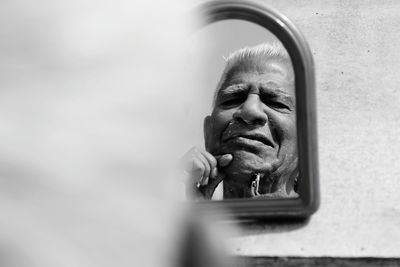 Senior man shaving reflecting on mirror