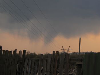 Panoramic view of wooden posts on field against sky during sunset