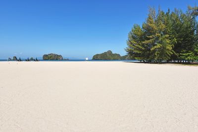 Scenic view of beach against clear blue sky