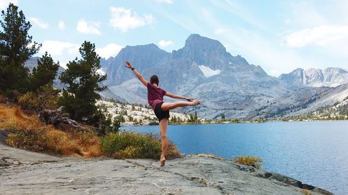 Full length of woman jumping on rock