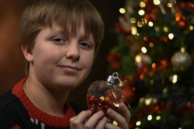 Portrait of young boyholding christmas decoration