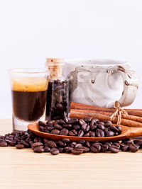 Close-up of roasted coffee beans on table against white background