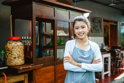 Portrait of young woman standing at home