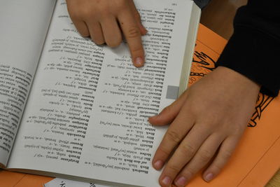 Midsection of woman reading book on paper