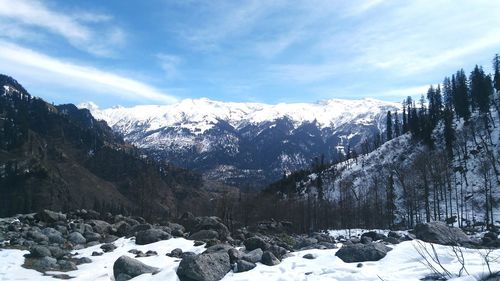 Scenic view of snowcapped mountains against cloudy sky