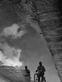 High angle view of people riding bicycle on puddle