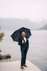 Full length portrait of man standing in rain