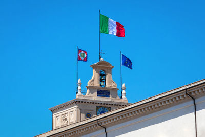 Low angle view of flag against clear blue sky